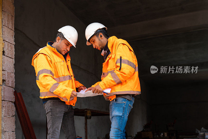 Two engineers having business meeting at construction site